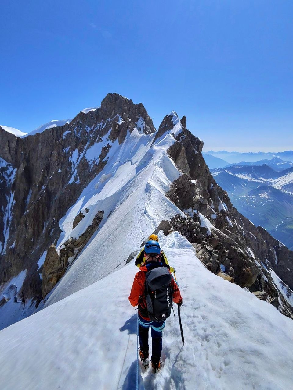 Mont Blanc ridge — Ed ascending steep snow arête, Ortovox pack, crampons, blue helmet